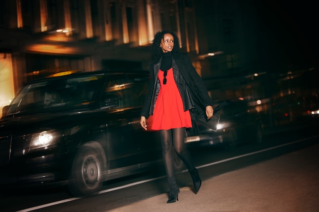 Free photo full shot woman posing at night with flash