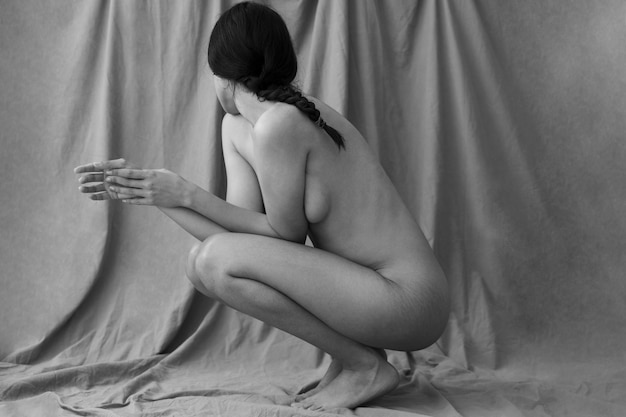 Full shot woman posing nude in studio