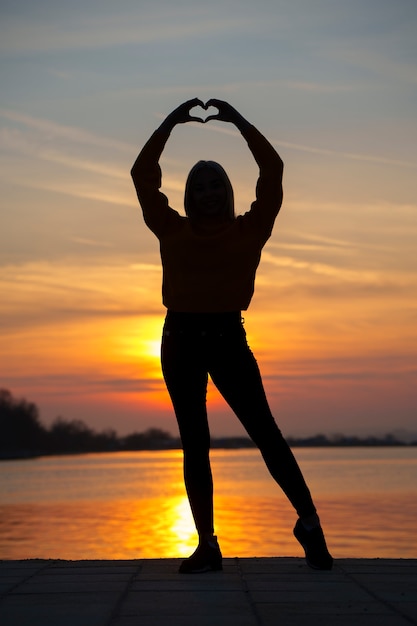 Free photo full shot woman posing at sunset