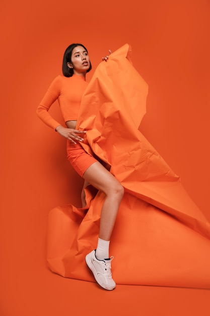 Free photo full shot woman posing with orange outfit