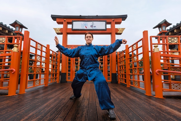 Full shot woman practicing tai chi outside