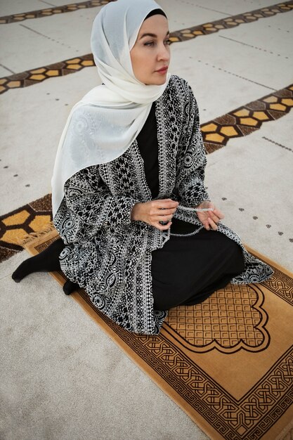 Full shot woman praying indoors