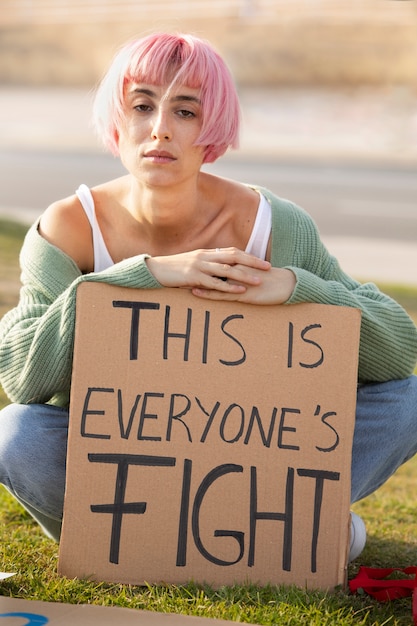 Full shot woman protesting with banner