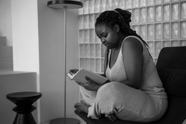 Full shot woman reading on chair