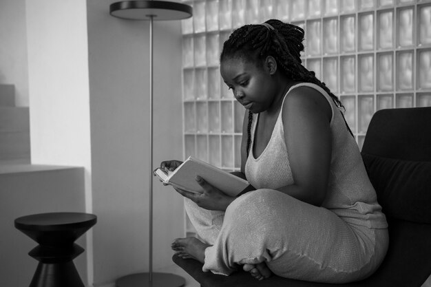 Full shot woman reading on chair