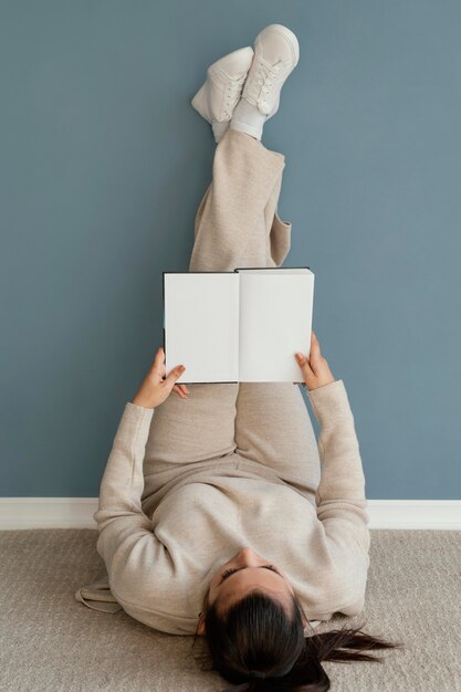 Full shot woman reading on floor