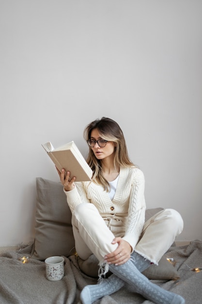 フルショットの女性が家で読書