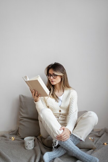 Женщина в полный рост читает дома