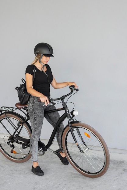 Женщина в полный рост готова кататься на велосипеде