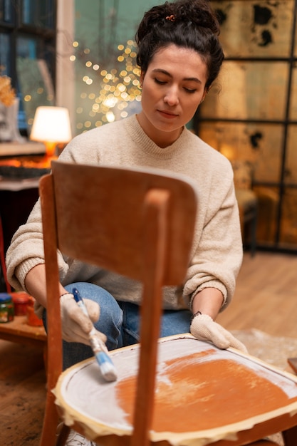 Free photo full shot woman restoring wooden furniture