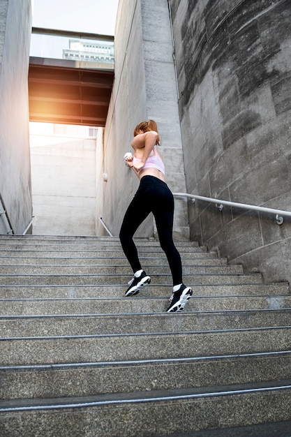 Full shot woman running up stairs