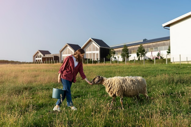 Free photo full shot woman shepherd petting sheep