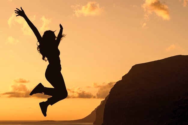 Full shot woman silhouette jumping