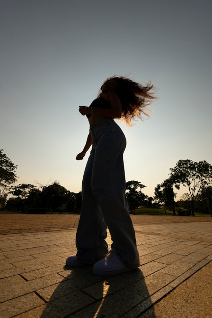 Free photo full shot woman silhouette posing at sunset