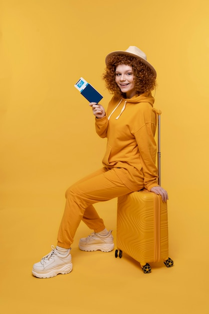 Full shot woman sitting on baggage