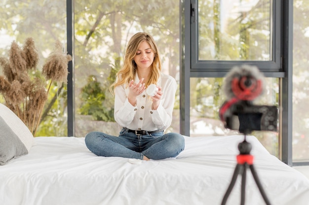 Full shot woman sitting on bed