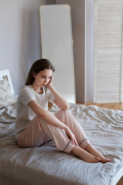 Full shot woman sitting in bed