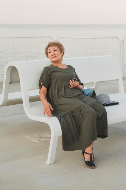 Free photo full shot woman sitting on bench