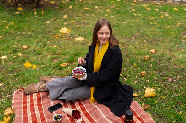 Full shot woman sitting on blanket