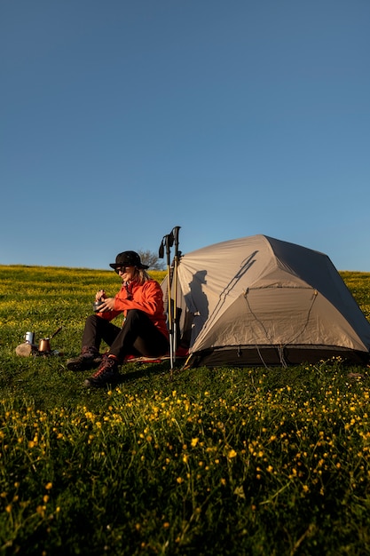 Full shot woman  sitting by the tent