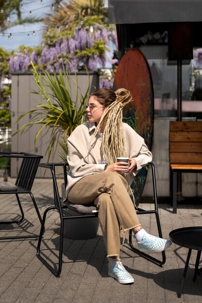 Full shot woman sitting on chair outdoors