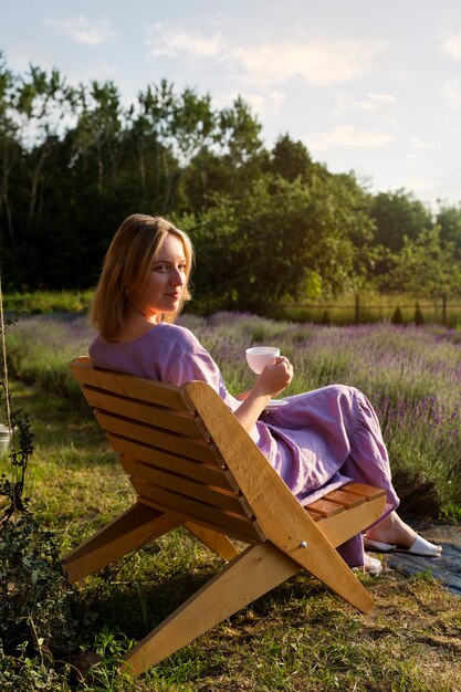 Full shot woman sitting on chair outdoors