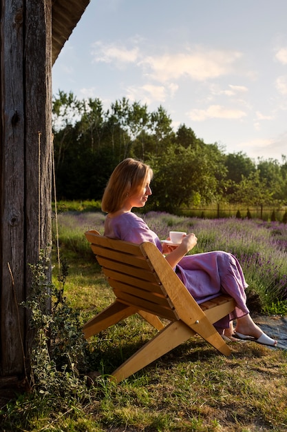 Full shot woman sitting on chair outdoors