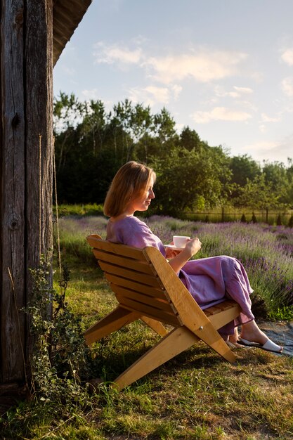 Full shot woman sitting on chair outdoors