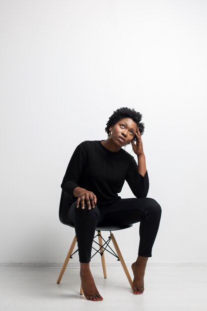 Full shot woman sitting on chair