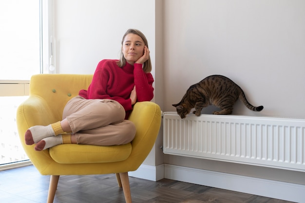 Foto gratuita donna della foto a figura intera che si siede sulla sedia