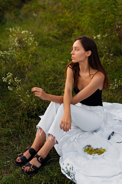 Full shot woman sitting on cloth