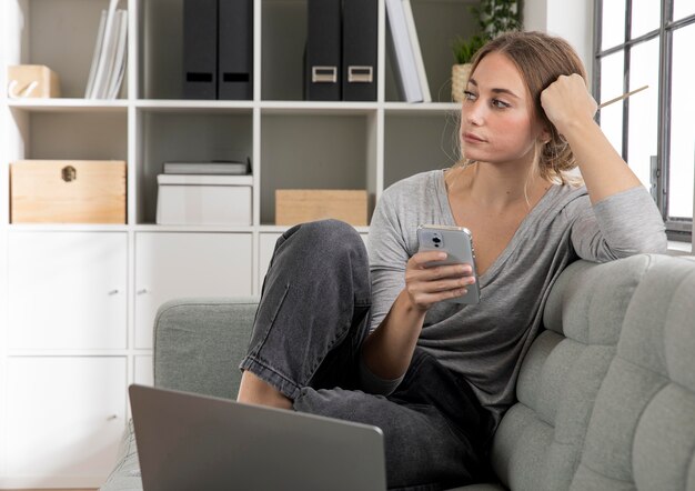 Full shot woman sitting on couch