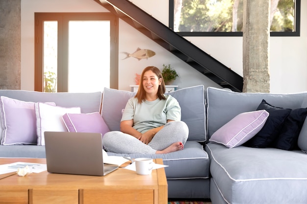 Full shot woman sitting on couch