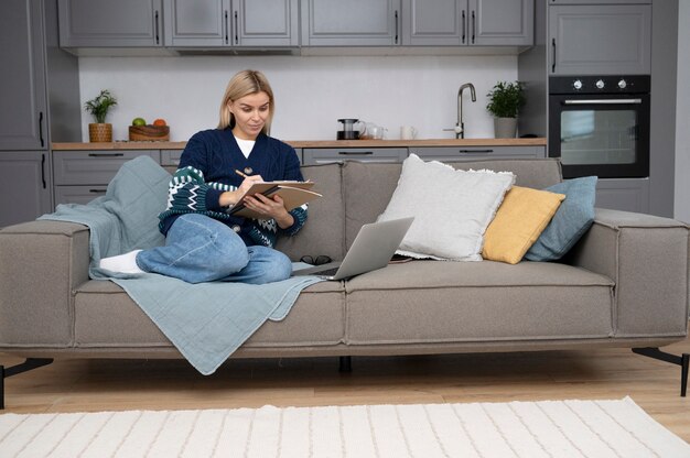 Full shot woman sitting on couch