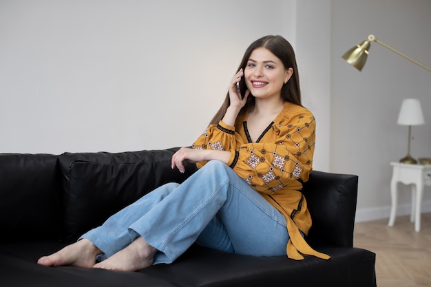 Full shot woman sitting on couch