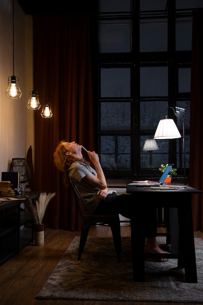 Free photo full shot woman sitting at desk