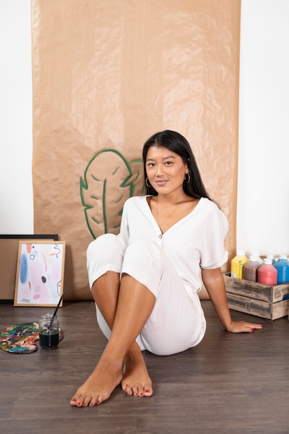 Full shot woman sitting on floor