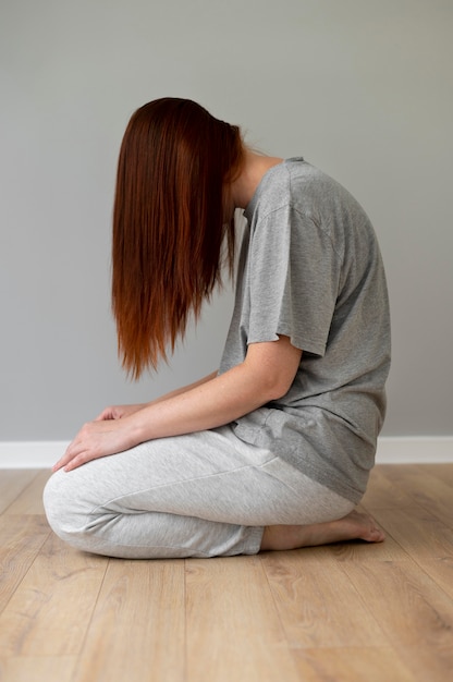 Full shot woman sitting on floor