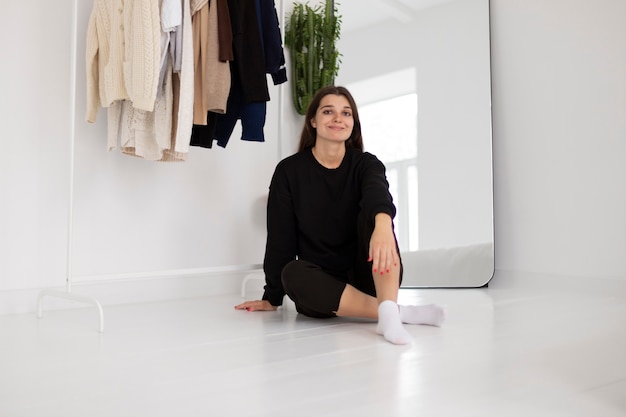 Full shot woman sitting on floor