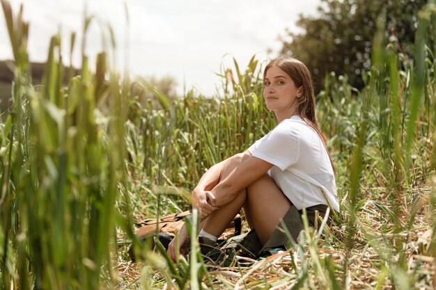 草の上に座っているフルショットの女性