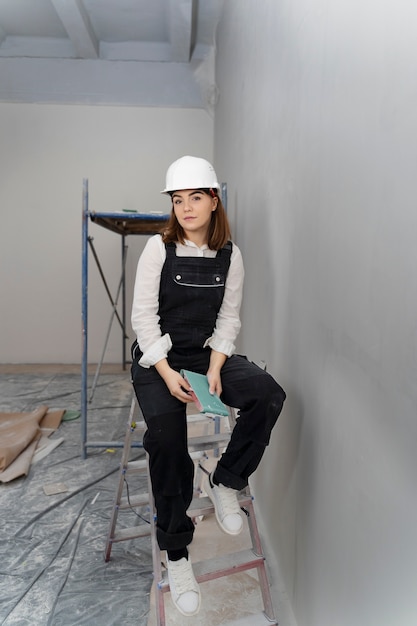 Full shot woman sitting on ladder