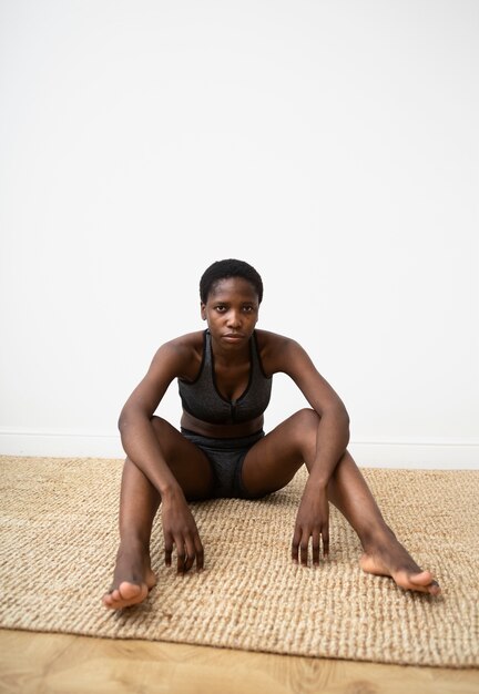 Full shot woman sitting on mat