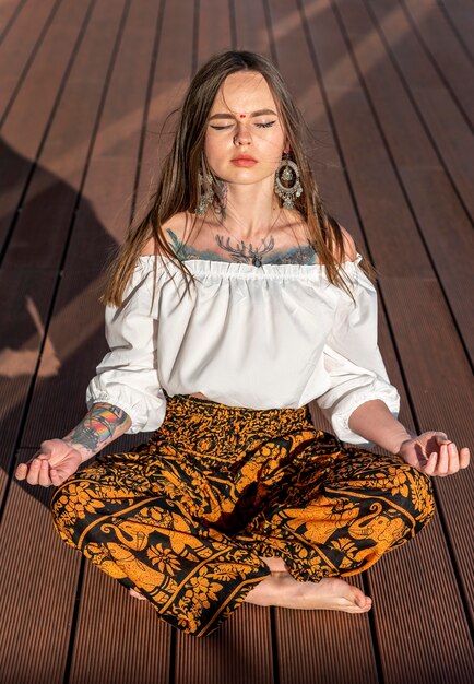Женщина в полный рост сидит и медитирует