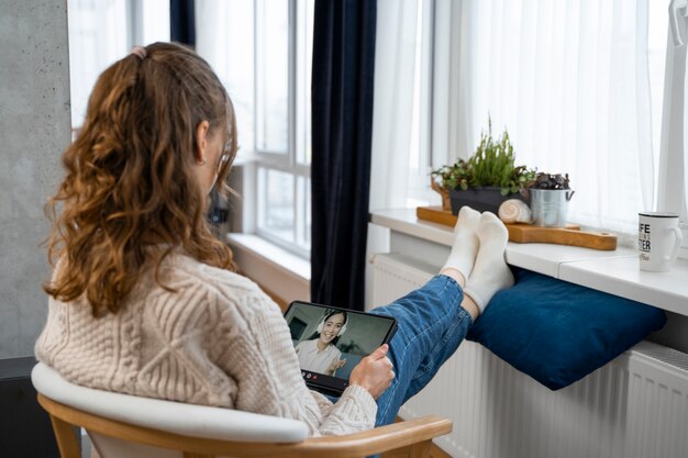 full shot woman sitting near heater