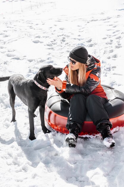 かわいい犬と屋外に座っているフルショットの女性