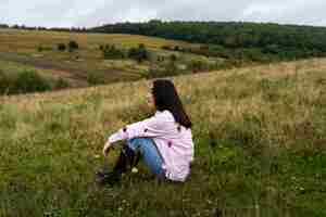 Free photo full shot woman sitting outdoors