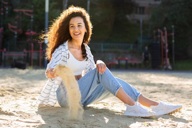 Full shot woman sitting on sand