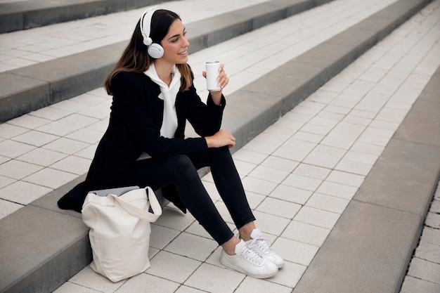 Full shot woman sitting on stairs outdoors