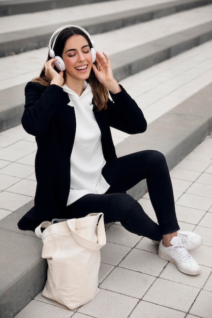 Free photo full shot woman sitting on stairs