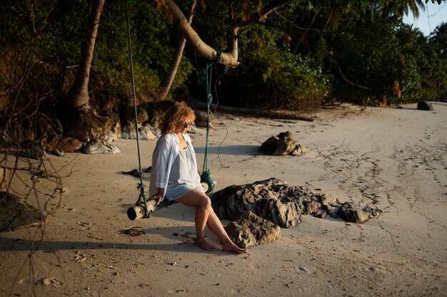 Full shot woman sitting on a swing